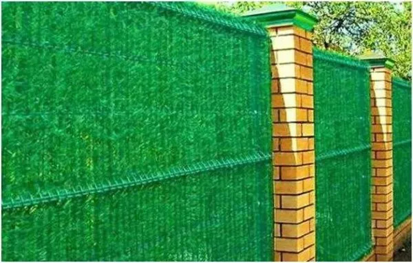 зеленая стена - сетка рабица задекорированная искусственной хвоей