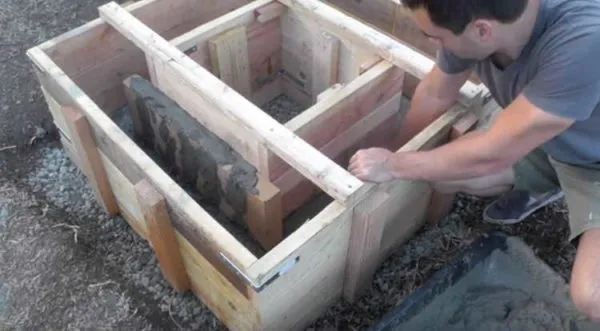 элементы опалубки закрепляют друг относительно друга, опалубку крепят к грунту и заполняют бетоном