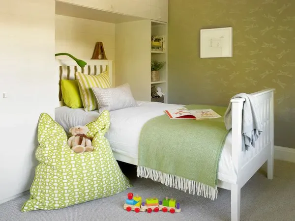 подушка с орнаментом зеленого оттенка около детской кровати