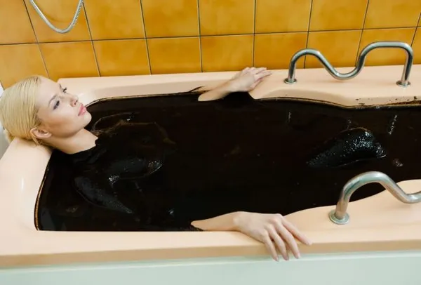 девушка лежит в грязевой ванне