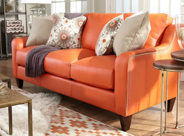кожаный диван оранжевого цвета в интерьере комнаты для гостей