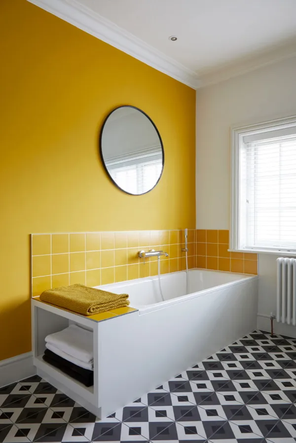 ванная с желтой стеной и черно-белым мозаичным полом