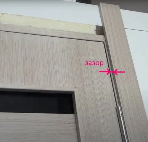 на фото видно зазор между наличником и краем дверной коробки.